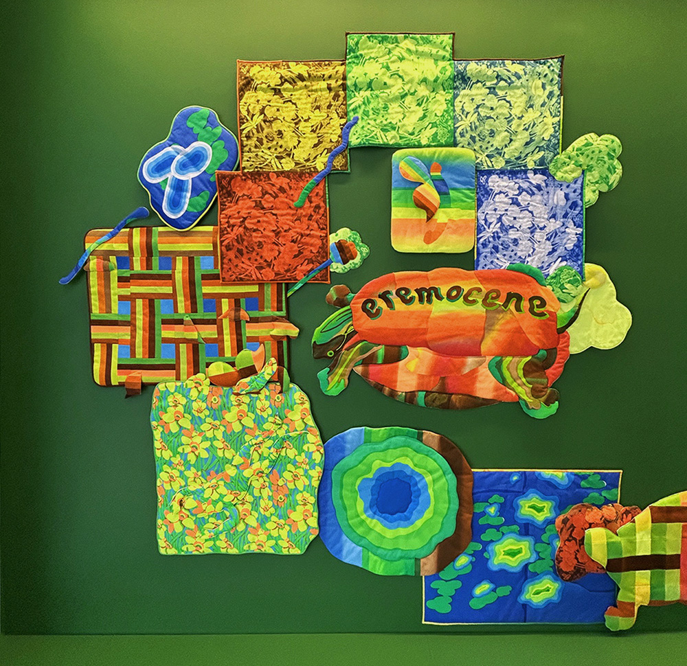 quilt with bright floral pattern in green, blue, orange, and yello