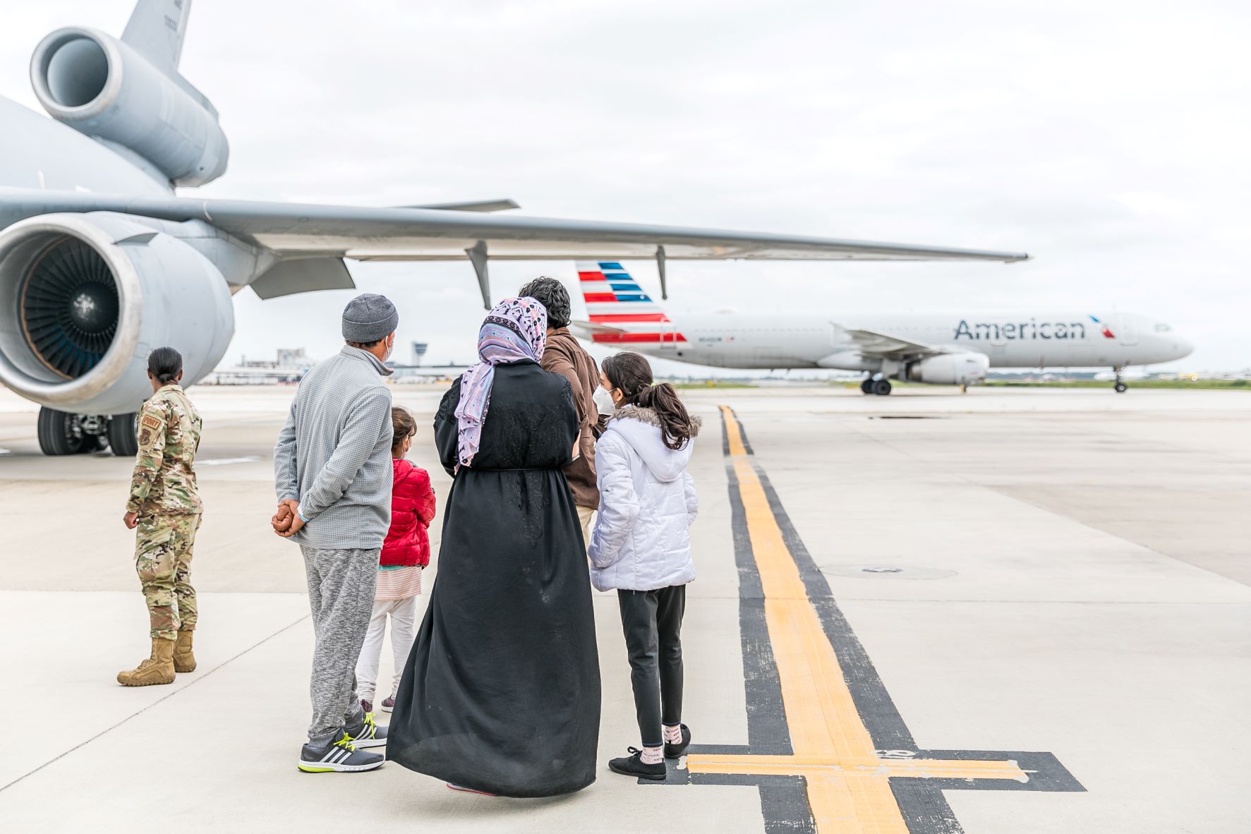Refugees standing in front of plane