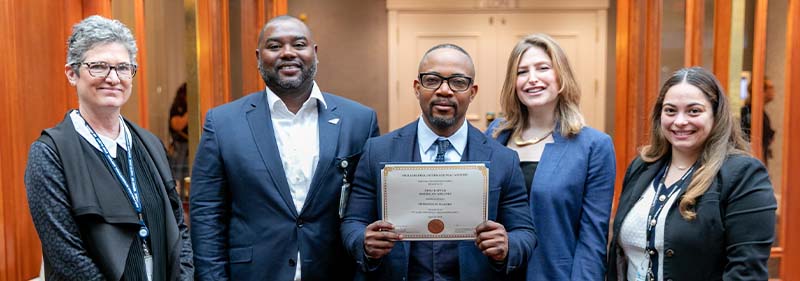 Atsu holding awards with colleagues 