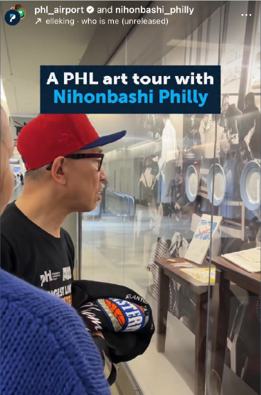 A PHL art tour with Nihonbashi. Profile of man wearing cap and glasses viewing encased display of restaurant table and plates