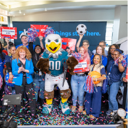 group of employees and swoop cheering with confetti falling