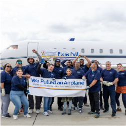 group of people cheering holding a sign that says, "we pulled an airplane".