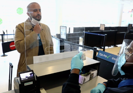 man wearing face protection while waiting at customs